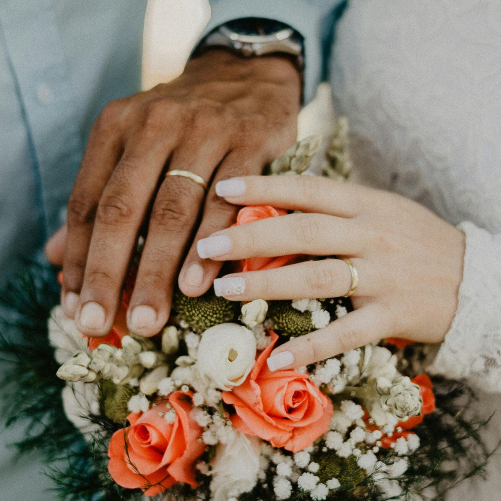 pexels-photo-1730877-1730877 Hands of the bride and groom with wedding rings and floral bouquet, symbolizing love and commitment.